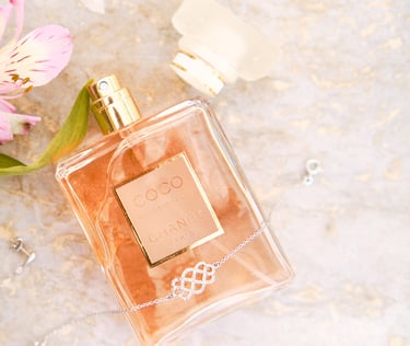 a bottle of perfume next to a flower