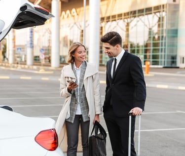 a man and woman standing in front of a car