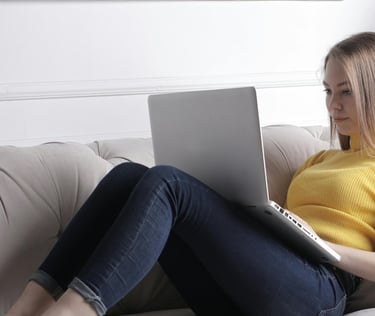 Businesswoman writing on PC on a couch