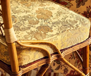 Chaise avec un coussin recouvert d'un coussin au tissu jaune et floral