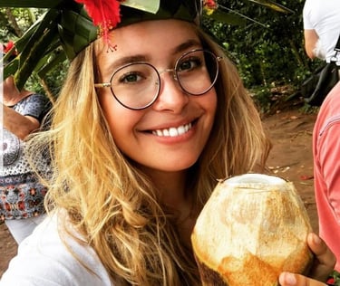 Tourist drinking fresh young coconut dafu at Zanzibar spice farm during guided spice tour with local expert