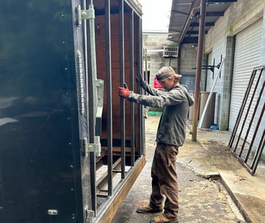 a man standing next to a trailer frame door
