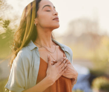 Femme les yeux fermés, main sur le cœur, exprimant gratitude et sérénité