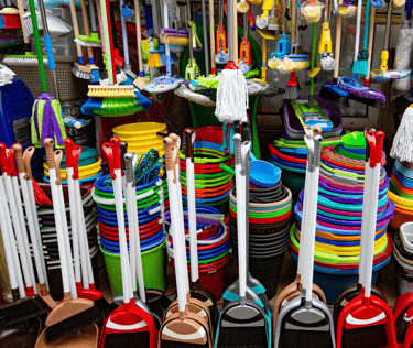 a bunch of different colored plastic brooms and brooms