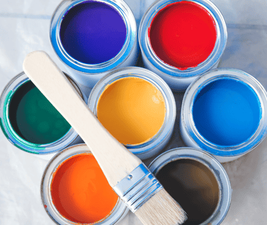 a paintbrush and paint cans of different colors