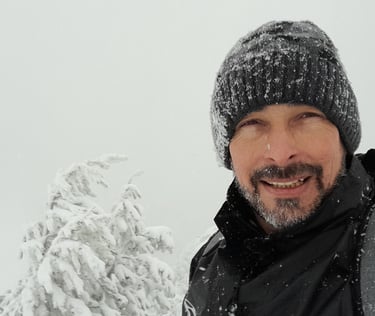a man in a black jacket and a hat on a snowy day