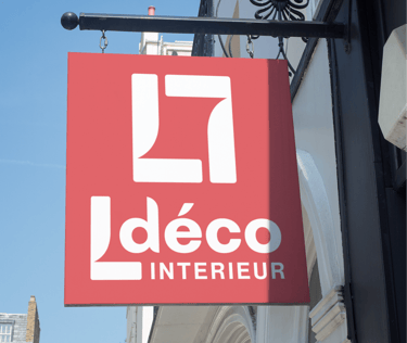Panneau rouge suspendu pour une entreprise de design d'intérieur contre un ciel bleu