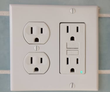 A white four plug outlet with a GFCI on the right 
