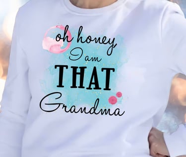 Woman in a white sweatshirt with a watercolor wash and the words "Oh honey I am THAT Grandma."