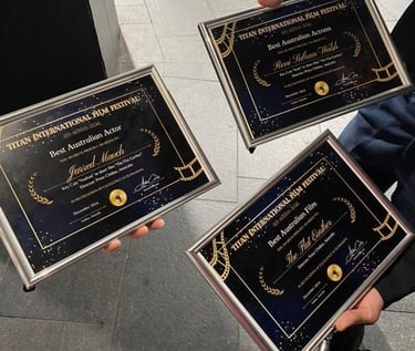 three people holding up plaques with their awards
