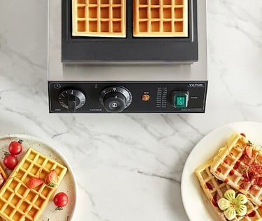 Professional commercial waffle maker with freshly baked golden waffles on plates.
