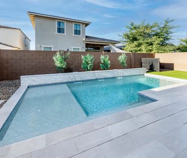 Modern geometric pool with pale blue water and light grey tiles plus a shallow sun shelf.