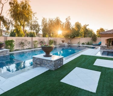 Geometric modern pool with reflective blue water and beige tiles set beneath sunset lighting