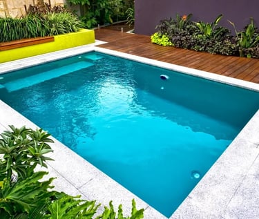 Minimalist rectangular pool with deep teal water, smooth light stone tiles and modern landscaping