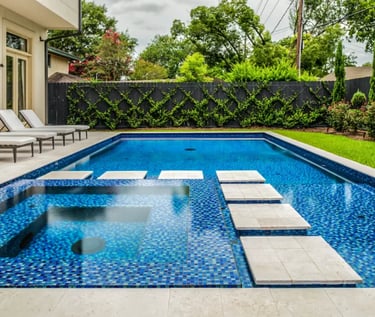 Fully tiled pool with stepping pads, deep blue water and small blue mosaic tile interior.