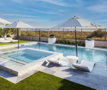 Geometric pool with crystal blue water, white marble-look tiles and an elevated spa ledge