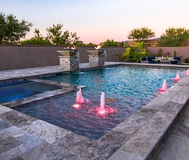 Luxury geometric pool with spa, soft blue water, light stone tiles and illuminated water jets