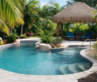 Freeform tropical pool with turquoise water and light stone coping, surrounded by lush greenery.