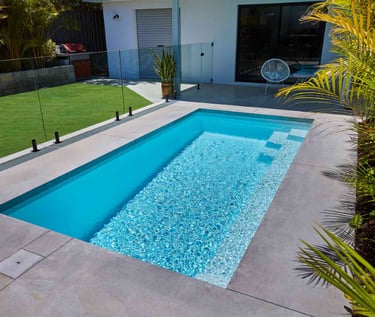 Minimalist courtyard pool with pale aqua water and light tiled interior, clean modern rectangular de