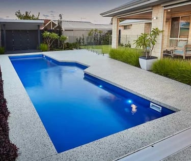 Modern rectangular pool, deep blue water, smooth blue interior with light concrete surround