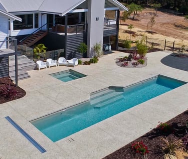 Modern lap pool with clean rectangular design, soft aqua water and light concrete-style tiling.