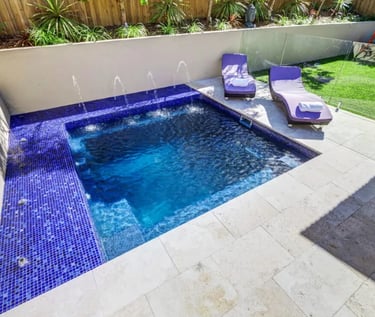 Compact square pool with rich blue water and cobalt mosaic tile interior