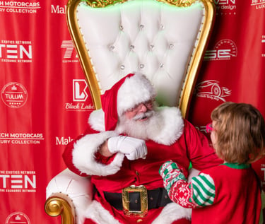 The Santa Cowboy gets a fist bump from a Make A Wish participant