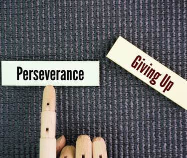 a person's hand pointing to a sign