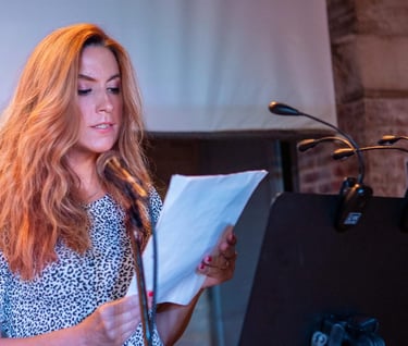 a woman reading a book and holding a microphone