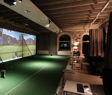 a man is playing golf in a room with a large screen
