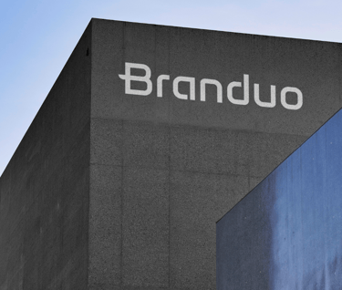 Fachada do Estúdio Criativo Branduo, com textura de cimento cinza escuro e letreiro em branco.