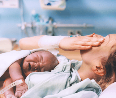 Femme qui vient de mettre au monde son enfant avec émotion