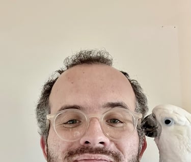 a man with glasses and a parrot on his head