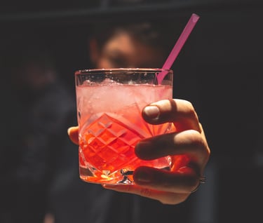 a person holding a drink in a glass