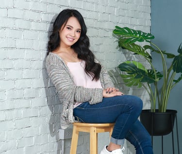 Lian sitting on a stool in a room.