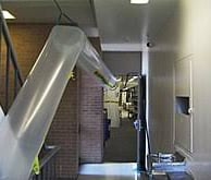 a long metal pipe in a hallway with a sink and a sink