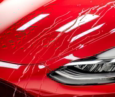 a red tesla detailing car with a shiny ceramic coating hood and a shiny cleaned clear headlights