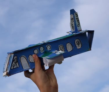 photo of Childs hand holding up cardboard airplane