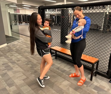 Sara and and student holding babies while talking