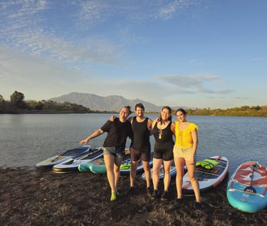 Jovenes disfrutando de un día soleado en la natulareza realizando una experiencia de stand up paddle
