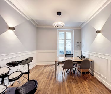 a room with a table and chairs and a drum set up