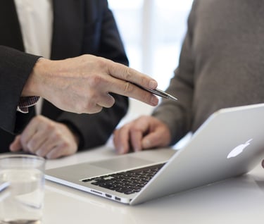 a man pointing at a laptop computer screen