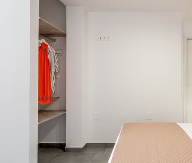 a bedroom with a brick wall and a bed with a bed and a closet