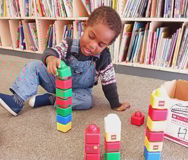 Little boy playing with lego blocks at a library