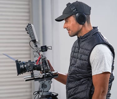 a man in a black vest and a camera with rode wireless pro