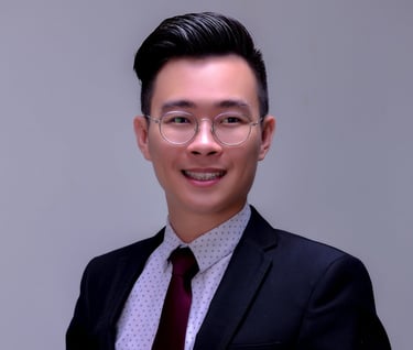 a man in a suit and tie standing in front of a white wall