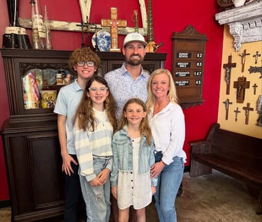 a photo of the family that owns race ready events standing in front of a bright red backdrop