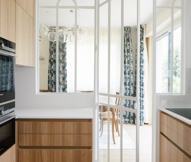 a kitchen with a large window and a table with chairs