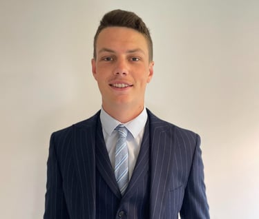 daniel stansbie head shot in a blue pin stripe suit