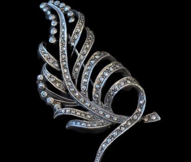 a silver and diamond feather brooch